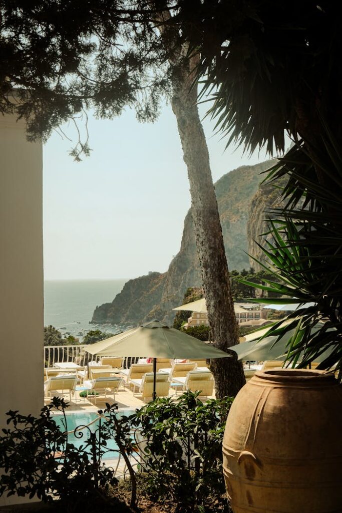 Relaxing Mediterranean resort view in Capri, Italy, featuring deckchairs and sunshades by a pool, ideal for travel and leisure seekers.