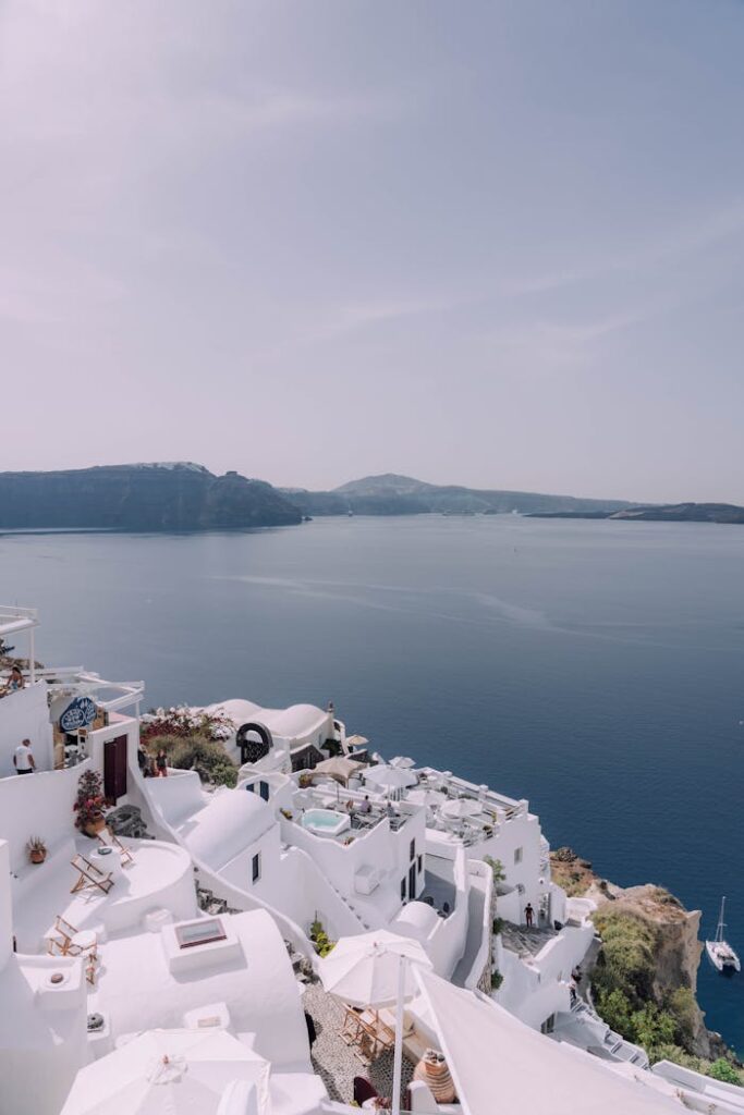 Capture a stunning view of Santorini's iconic white architecture against the serene Aegean Sea.