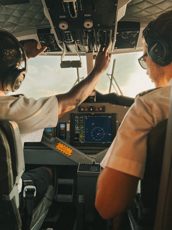 Two pilots operating the cockpit controls during a flight over Seychelles.