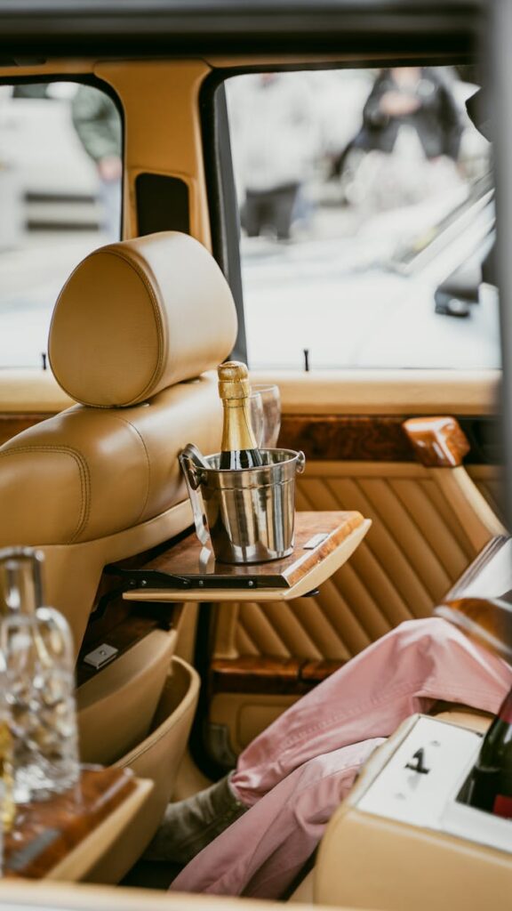 Exquisite car interior featuring champagne in a bucket, epitome of luxury and sophistication.