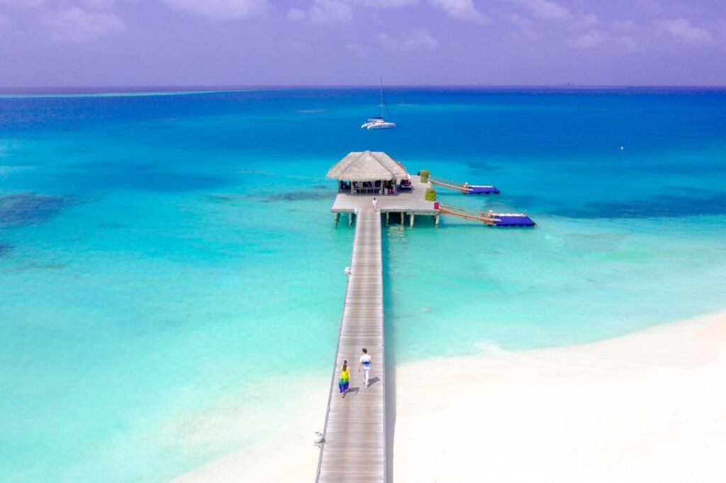 A breathtaking aerial view of a tropical island pier with turquoise waters in the Maldives.