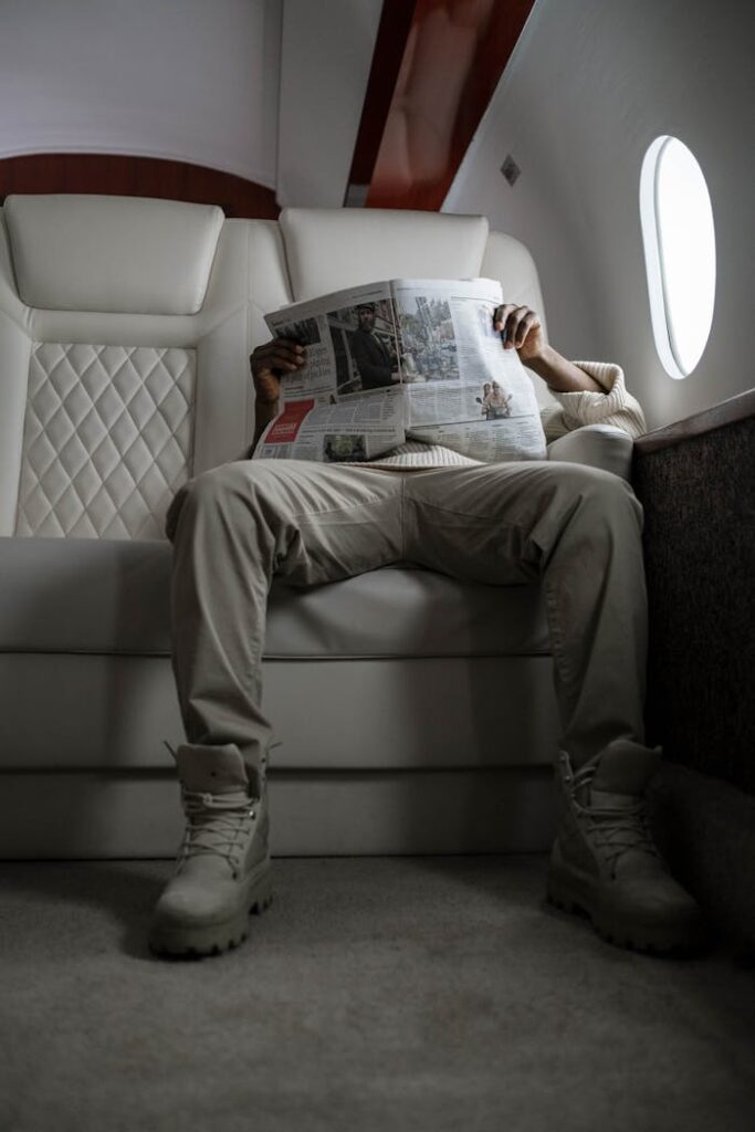 A man reading a newspaper while seated in a luxurious private jet interior, capturing serenity.